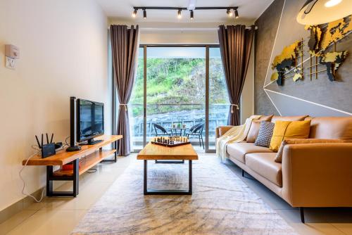 un soggiorno con divano e TV di Serene Mossy Family Cottage(2-7pax) 10 Min to BOH a Cameron Highlands