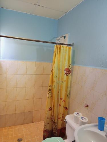 a bathroom with a shower curtain and a toilet at Surfari Bocas in Bocas del Toro