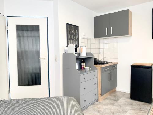 een kleine keuken met een koelkast en een wastafel bij 21qm² Business Apartment in Bielefeld