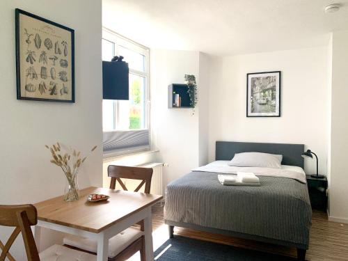 een kleine slaapkamer met een bed en een tafel bij 21qm² Business Apartment in Bielefeld
