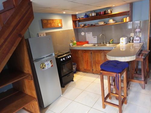 a kitchen with a refrigerator and a table in it at Surfari Bocas in Bocas del Toro