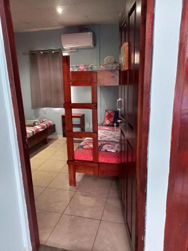 a room with two bunk beds and a doorway at Surfari Bocas in Bocas del Toro