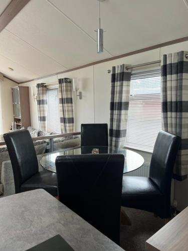 a living room with a table and chairs at Maneight Luxury Lodge with hot tub in New Cumnock