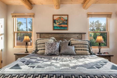 a bedroom with a large bed with two windows at Linda - Walk to The Plaza in Santa Fe