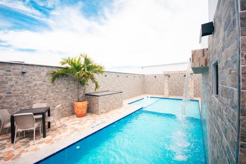 a swimming pool with a table and a water fountain at Hotel Buddha Mystic By Del Toro in Doradal