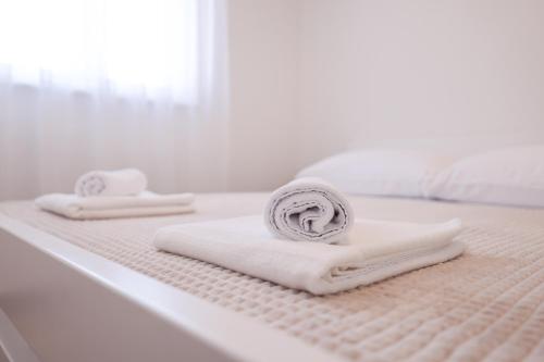 dos toallas sentadas encima de una cama en New Family Apartments with private parking near Zadar en Murvica