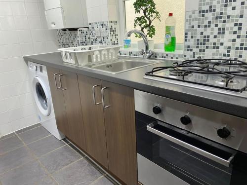 a kitchen with a sink and a washing machine at House in Medway in Gillingham