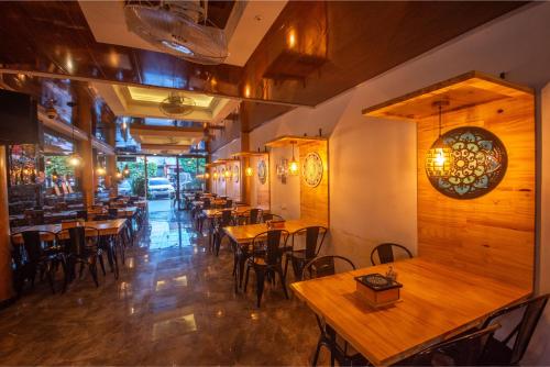 an empty restaurant with wooden tables and chairs at Hotel Buddha Mystic By Del Toro in Doradal