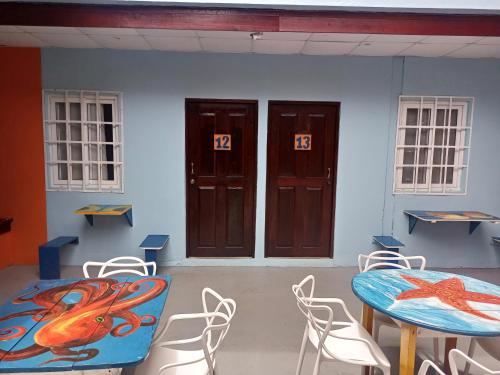 a room with a table and chairs and doors at Surfari Bocas in Bocas del Toro