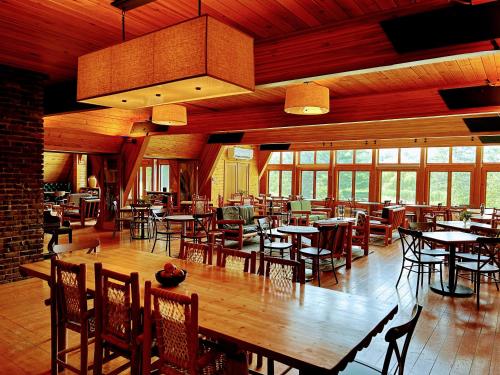 un restaurante con mesas y sillas de madera y ventanas en NewVida Preserve, en Wilmington