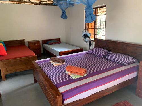 Un dormitorio con una cama con sábanas moradas y una ventana en Sahana Retreat, en Buttala
