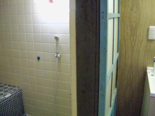 a bathroom with a shower with white tiles at Fukubatake in Yoshino