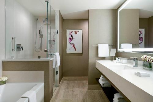 een badkamer met 2 wastafels, een bad en een douche bij JW Marriott Minneapolis Mall of America in Bloomington