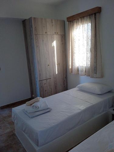 una camera da letto con un letto e un asciugamano sopra di Iliachtida apartments a Philotium