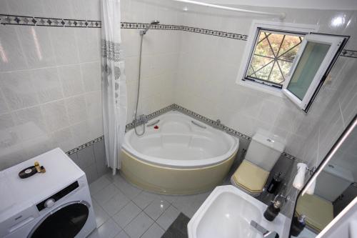 a bathroom with a tub and a sink and a toilet at Spiros House in Kynopiástai