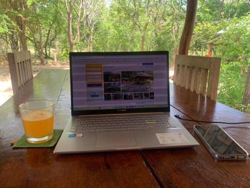 a laptop computer sitting on a table with a glass of beer at Sahana Retreat in Buttala