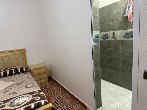 ein kleines Schlafzimmer mit einem Bett und einer Dusche in der Unterkunft إقامة الامل in Beni Mellal