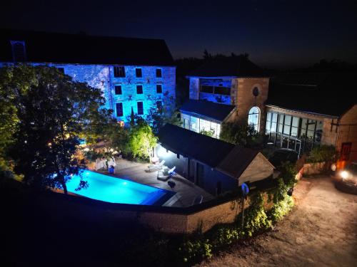 - une vue aérienne sur un bâtiment avec piscine la nuit dans l'établissement La minoterie : maison atypique d'hôte et de séminaires, 20min de La Rochelle, à Mauzé-sur-le-Mignon