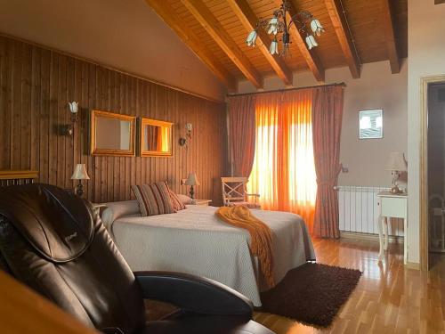 Un dormitorio con una cama y una silla dentro. en Ambar SPA. Azagalla Rural, en Casas del Abad