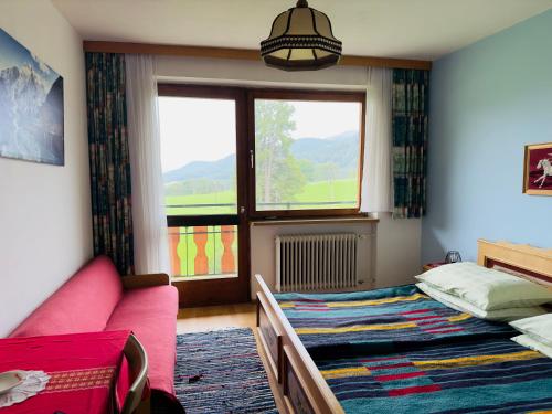 a bedroom with a bed and a couch and a window at Urlaub am Fieglerberg 
