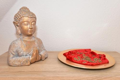 a statue of a buddha with a plate of food at Ferienwohnung Harmony in Leisnig