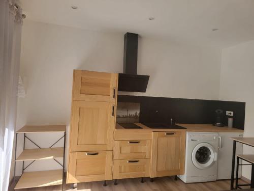 Il comprend une cuisine équipée d'une cuisinière. - un four supérieur à côté d'un lave-linge dans l'établissement STUDIO A 2 MN DE L A75, à Usclas-lʼHérault