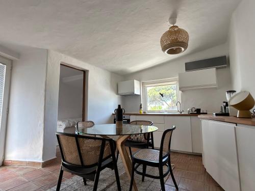 una cucina e una sala da pranzo con tavolo e sedie di Casa di Campara Villa Faro a Faro