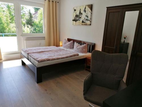 a bedroom with a bed and a chair and a window at cozy Apartment in der Nähe der BASF in Lauchhammer