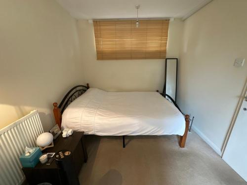 a small bedroom with a bed and a window at Private Room near Canary Wharf in London