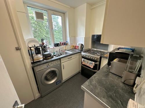 a kitchen with a sink and a washing machine at Private Room near Canary Wharf in London
