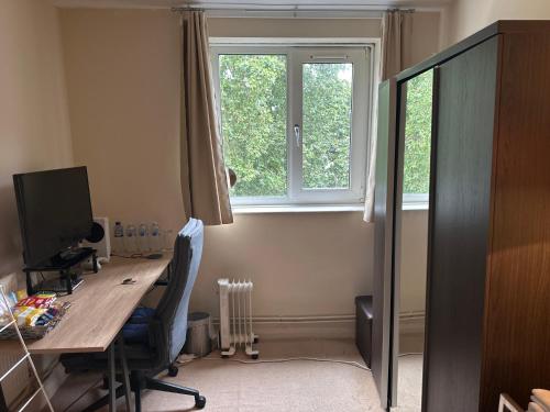 an office with a desk with a computer and a window at Private Room near Canary Wharf in London