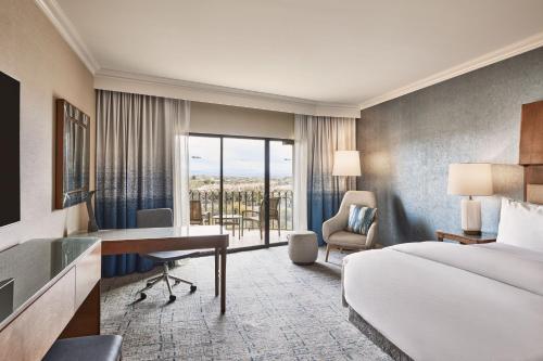 a hotel room with a bed and a desk and a bedroom at The Westin La Paloma Resort & Spa in Tucson