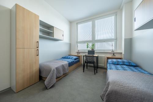 um quarto com 2 camas e uma secretária. em Penzion BIG HOUSE em Praga