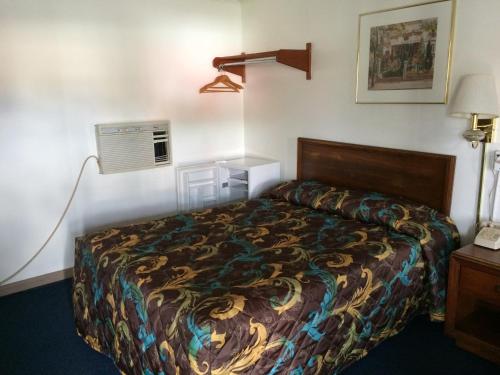 a hotel room with a bed and a air conditioner at Budget Inn - Scottsboro in Scottsboro