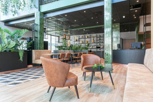 a restaurant with chairs and a table in a lobby at Distrikt Hotels Amsterdam Zaandam in Zaandam