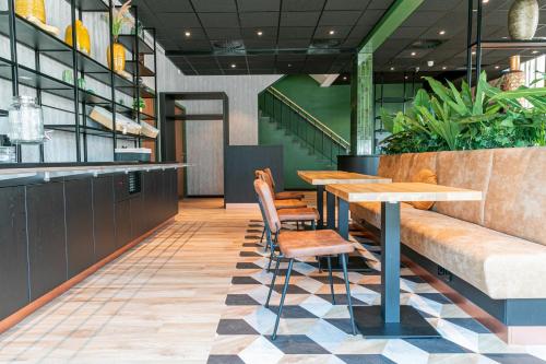 a restaurant with a table and chairs on a checkered floor at Distrikt Hotels Amsterdam Zaandam in Zaandam