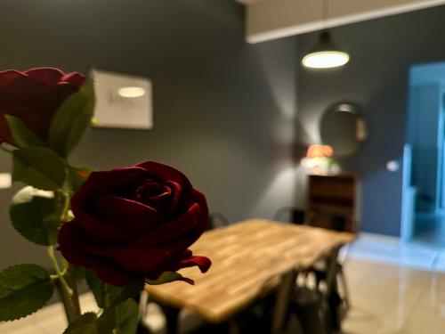 a vase with a red rose sitting next to a table at Queen’s Villa for 28Pax @Central of Penang in Jelutong