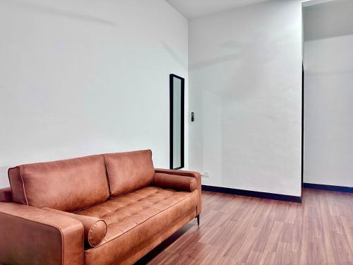 a brown leather couch sitting in a room at Queen’s Villa for 28Pax @Central of Penang in Jelutong