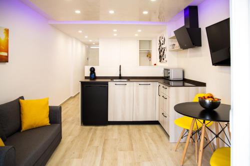 een keuken en woonkamer met een bank en een tafel bij Luxury Suite Borinquen with parking and swimming pool in Playa de las Americas