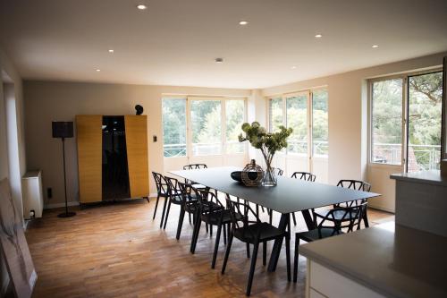 ein Esszimmer mit einem weißen Tisch und Stühlen in der Unterkunft Appartement du Mont de L’Enclus in Buisestraat