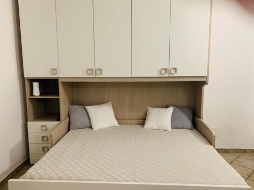 a bed in a room with white cabinets at Il Cortiletto in Somma Lombardo