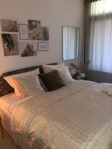 a large bed in a bedroom with photographs on the wall at Ferienwohnung Paula in Bad Harzburg