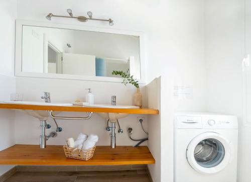 a bathroom with a sink and a washing machine at Apartamento Calan Bosch, Ciutadella in Cala'n Bosch