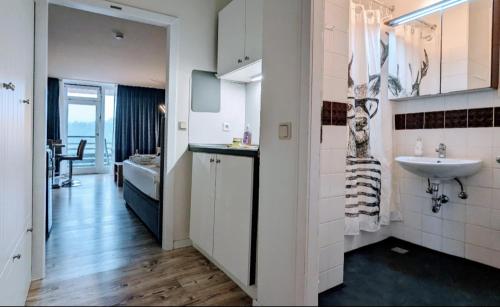 ein weißes Badezimmer mit einem Waschbecken und einem Waschbecken in der Unterkunft Kleine Freiheit App am See in Hahnenklee-Bockswiese