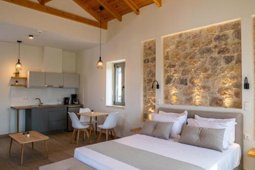1 dormitorio con 1 cama y cocina con mesa en Olivar Suites, en Plitra