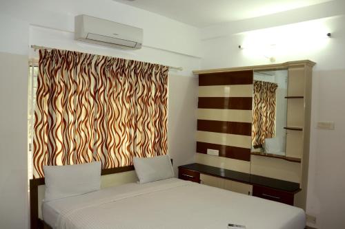 a bedroom with a bed and a window with a zebra curtain at Uthradam towers in Trivandrum
