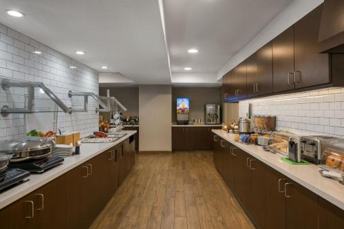 a large kitchen with brown cabinets and wooden floors at Residence Inn by Marriott Salt Lake City Downtown in Salt Lake City