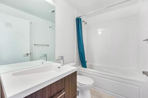 ein Badezimmer mit einem Waschbecken, einem WC und einer Badewanne in der Unterkunft Heart of Downtown Toronto! in Toronto