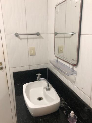 a bathroom with a sink and a mirror at Village Mamelucos frente para Praia do Flamengo in Salvador
