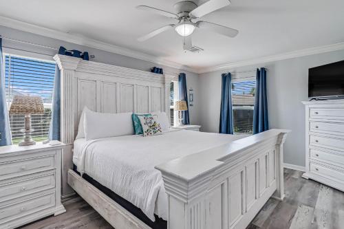 a white bedroom with a bed and a ceiling fan at Sparrow's Nest in Rockport